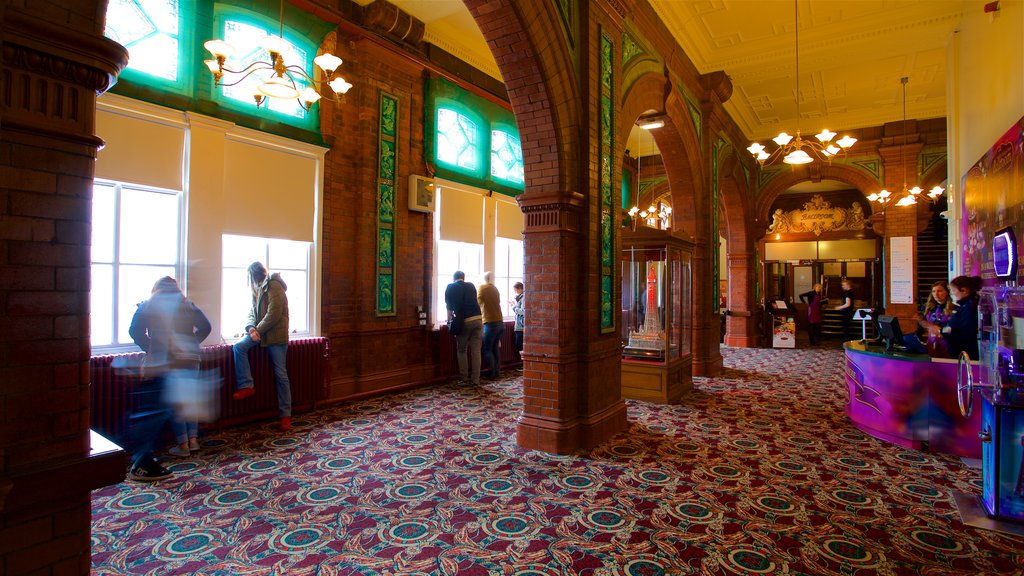 Blackpool Tower que incluye elementos patrimoniales y vista interna y también un pequeño grupo de personas