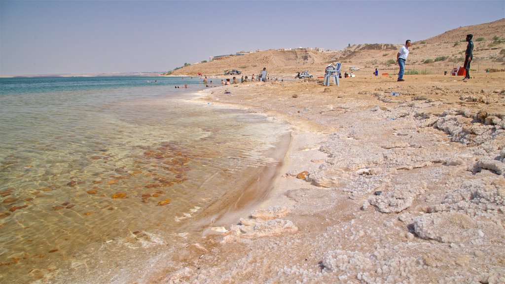 Sweimeh featuring a pebble beach and general coastal views as well as a small group of people