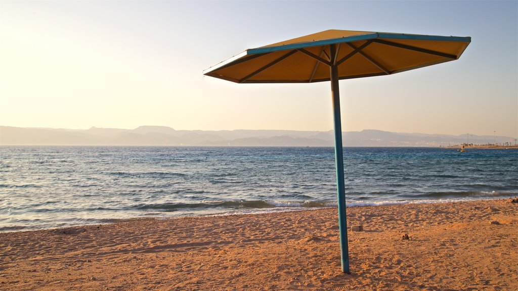 Aqaba inclusief een zonsondergang, een zandstrand en algemene kustgezichten