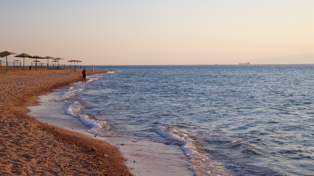 Aqaba ofreciendo una playa de arena, un atardecer y vista general a la costa