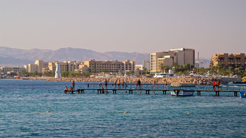 Aqaba caracterizando uma cidade litorânea e paisagens litorâneas assim como um pequeno grupo de pessoas