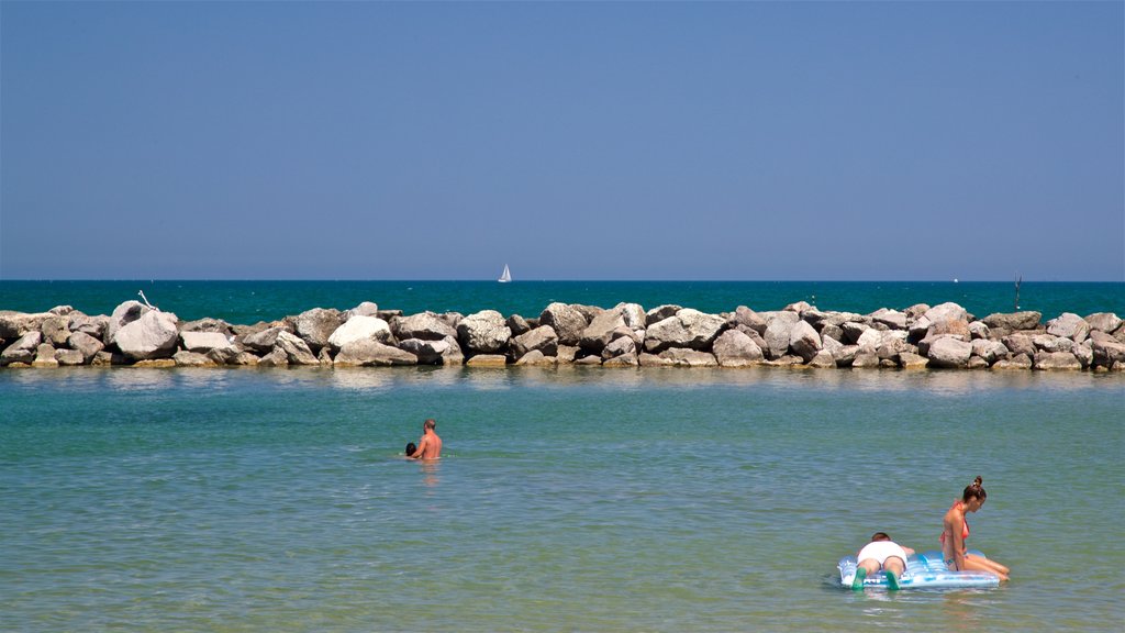 Torre Pedrera which includes general coastal views and swimming as well as a small group of people