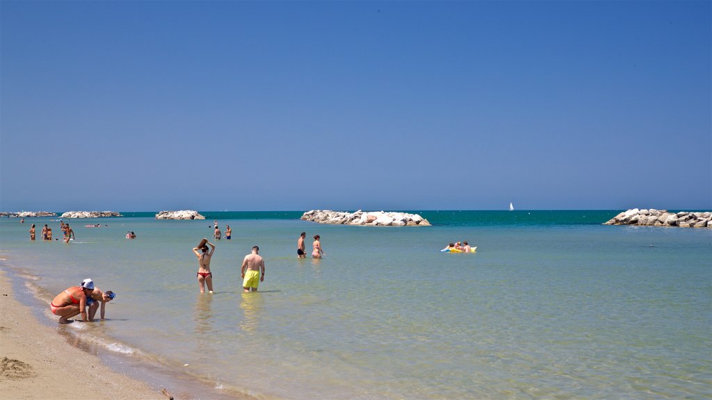 Torre Pedrera mostrando natação, paisagens litorâneas e uma praia de areia