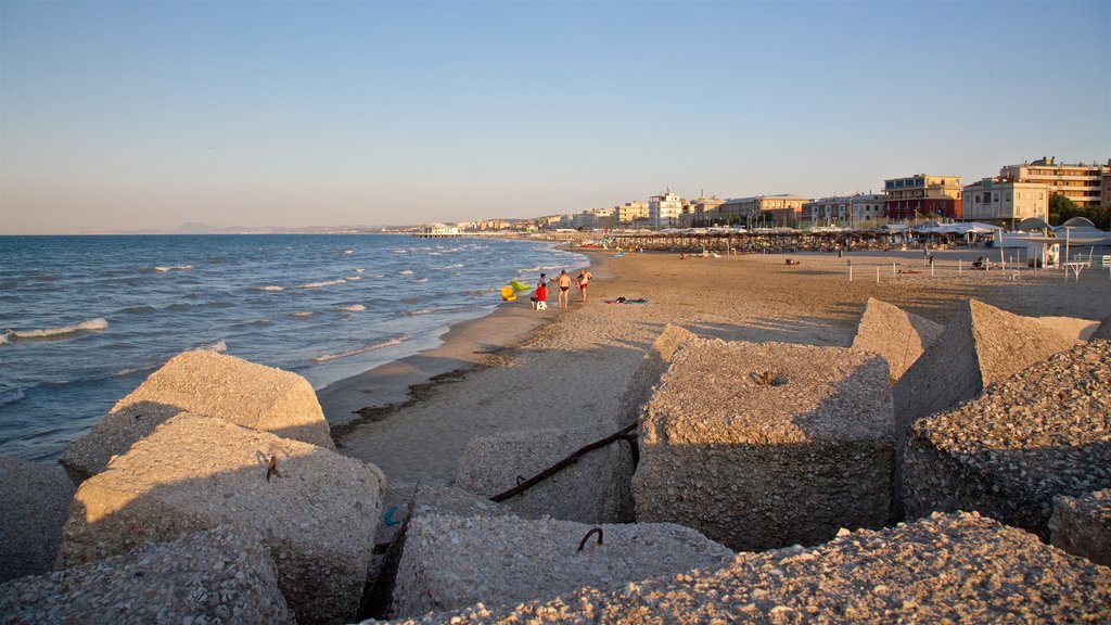 Senigallia which includes a sandy beach, a coastal town and a sunset