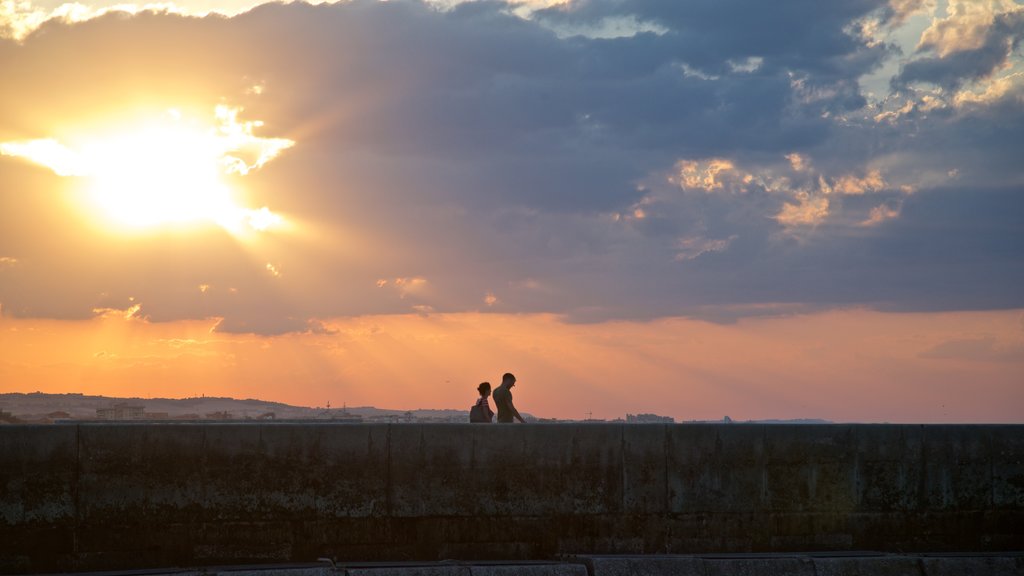 Senigallia mostrando una puesta de sol y vistas de paisajes y también una pareja