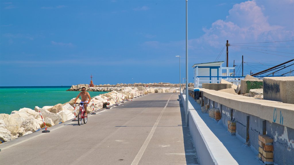 Porto de Giulianova mostrando ciclismo e paisagens litorâneas assim como um homem sozinho