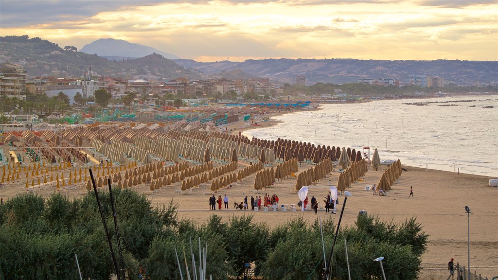 Pescara ofreciendo una playa de arena, un atardecer y una ciudad costera