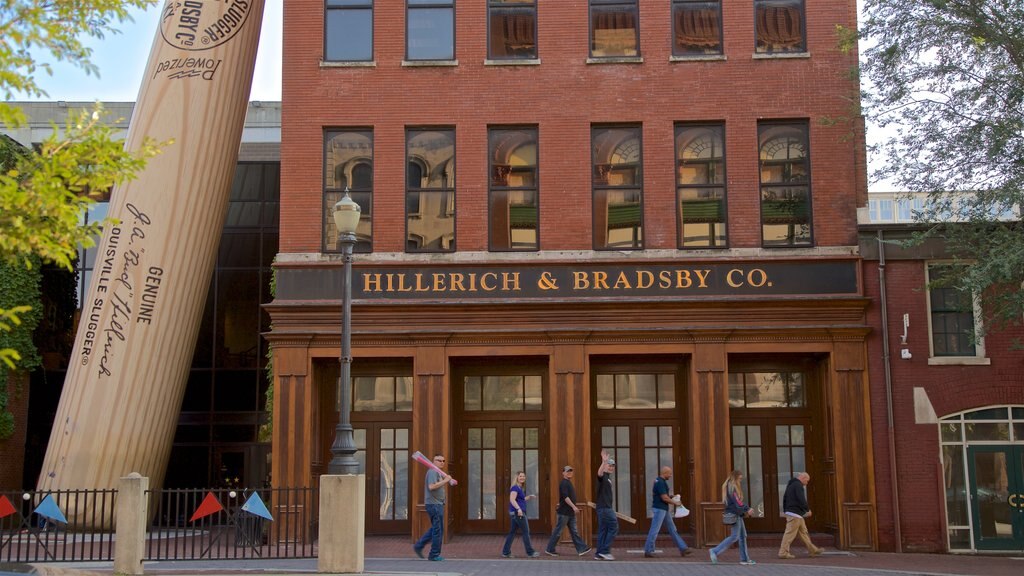 Louisville Slugger Museum which includes signage and outdoor art as well as a small group of people