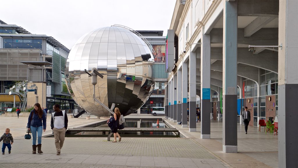 Millenium Square mostrando arte ao ar livre e cenas de rua assim como uma família