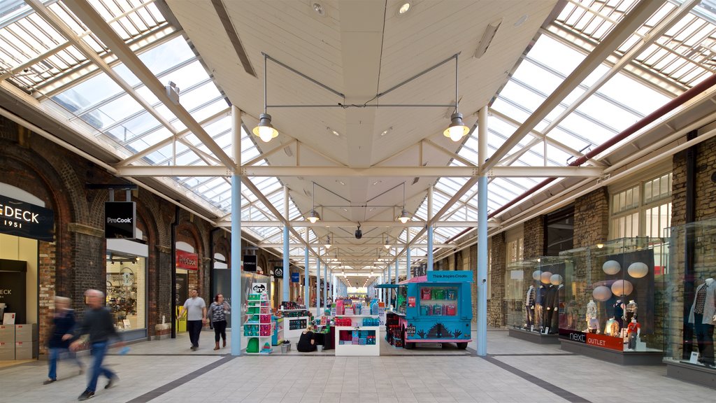 Swindon Designer Outlet que inclui compras e vistas internas assim como um pequeno grupo de pessoas