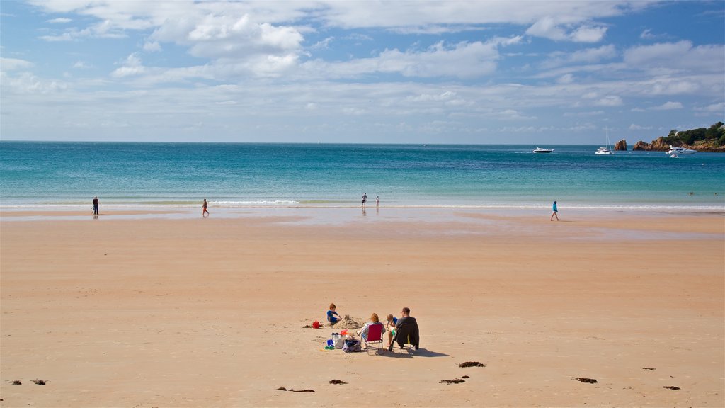 Praia da Baía de St Brelade mostrando uma praia de areia e paisagens litorâneas assim como uma família