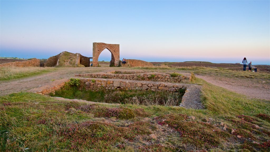 Grosnez Castle showing a sunset and building ruins as well as a couple