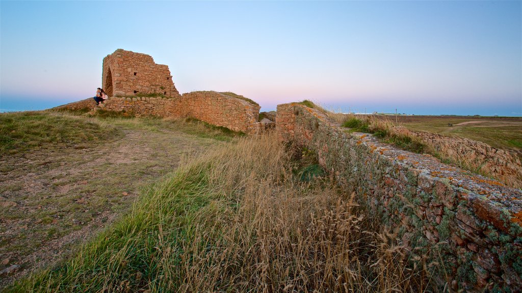 Grosnez Castle showing building ruins and a sunset