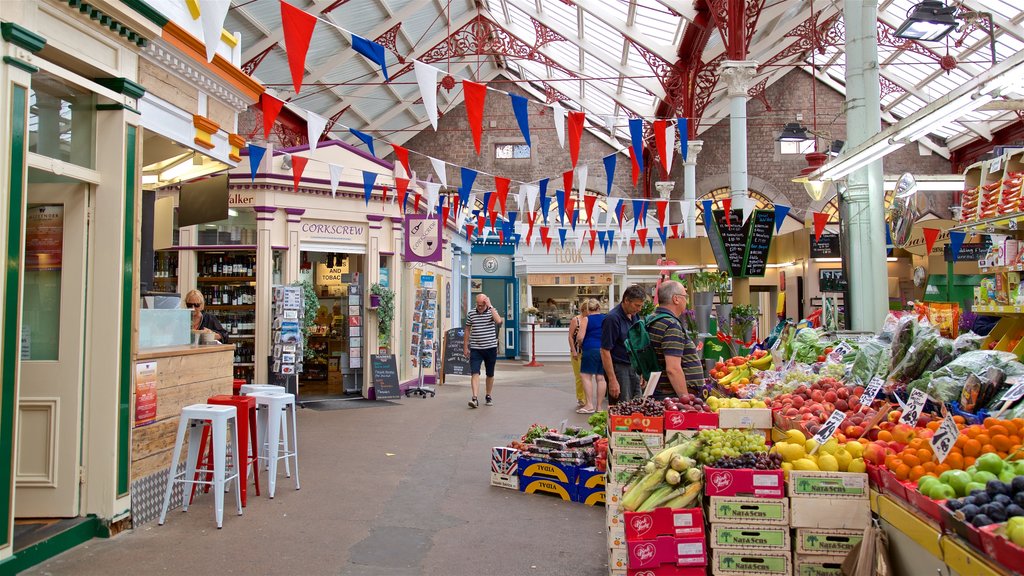 St. Helier Central Market showing markets and food as well as a small group of people