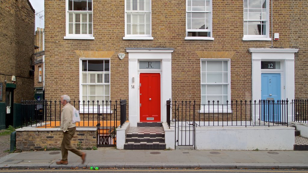 Mercado de Portobello Road que incluye una casa y escenas urbanas y también un hombre