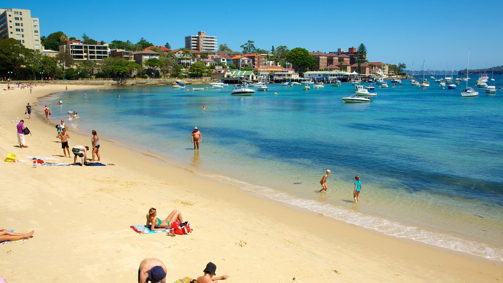 Playa de Manly ofreciendo una ciudad costera, una playa de arena y natación