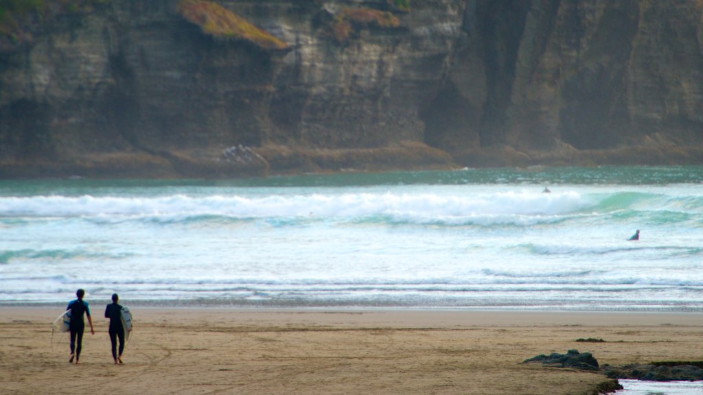 Piha Beach featuring surfing, landscape views and a sandy beach