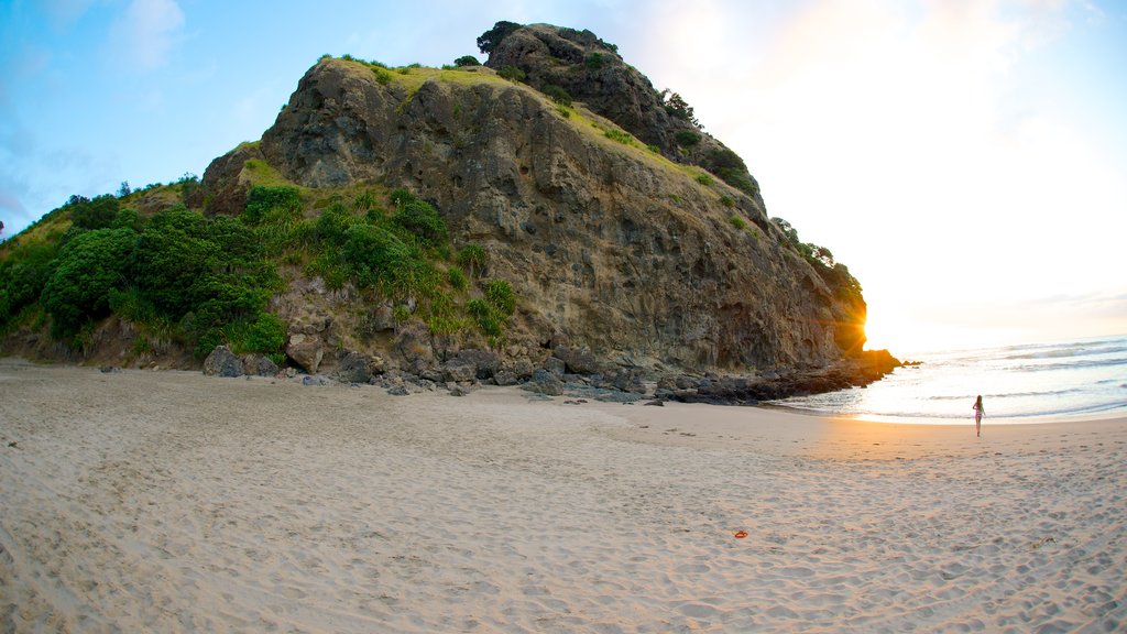 Piha Beach which includes a sunset, a beach and landscape views