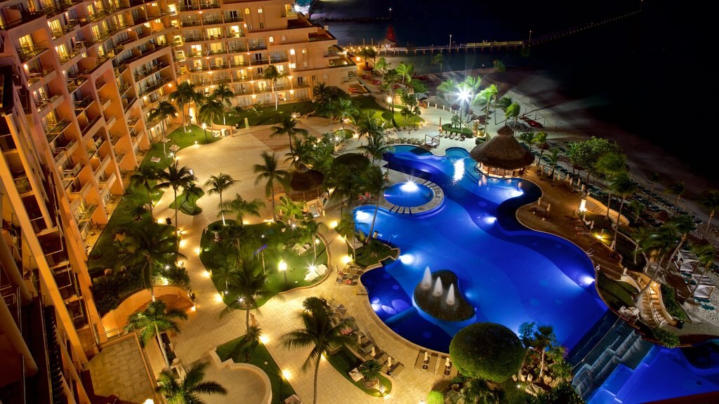 Cancún ofreciendo escenas nocturnas, una alberca y un hotel o resort de lujo