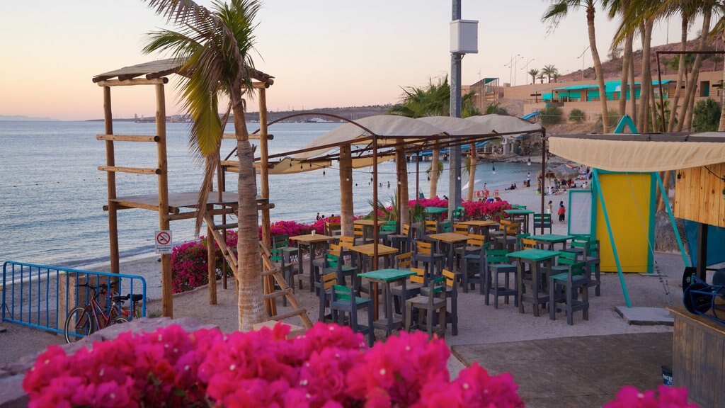 Playa El Coromuel mostrando uma cidade litorânea e um pôr do sol