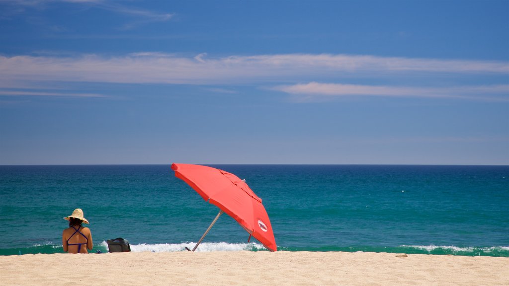 Plaza Costa Azul ofreciendo una playa y vistas generales de la costa y también una mujer