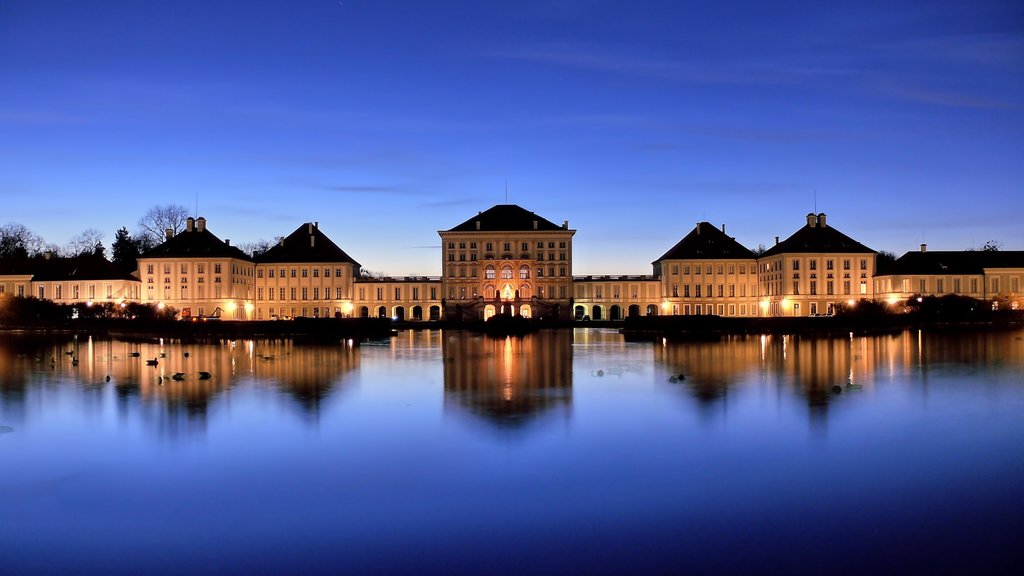 Nymphenburg Palace featuring a lake or waterhole, chateau or palace and a sunset