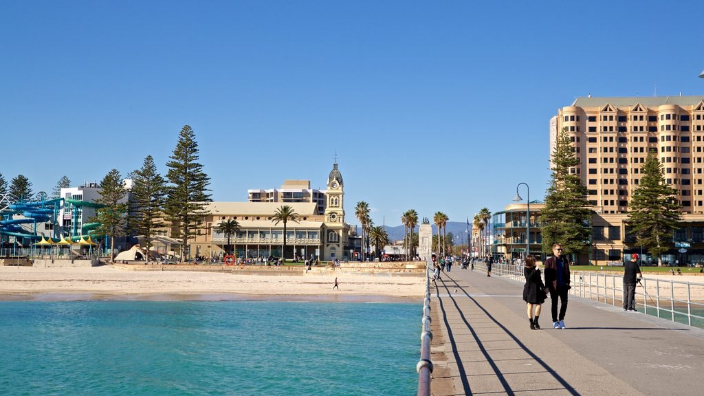 Malecón de Glenelg ofreciendo una ciudad costera y vista general a la costa y también una pareja