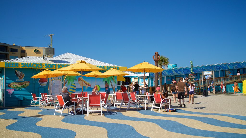 Cocoa Beach Pier showing a coastal town as well as a small group of people