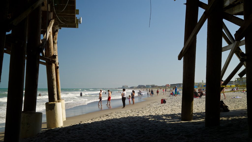 Cocoa Beach Pier featuring general coastal views and a beach as well as a small group of people