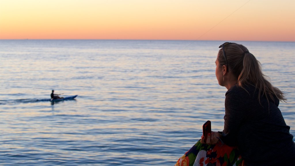 Cottesloe Beach which includes a sunset and general coastal views as well as an individual female