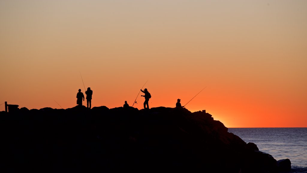 Cottesloe Beach which includes a sunset, general coastal views and rocky coastline