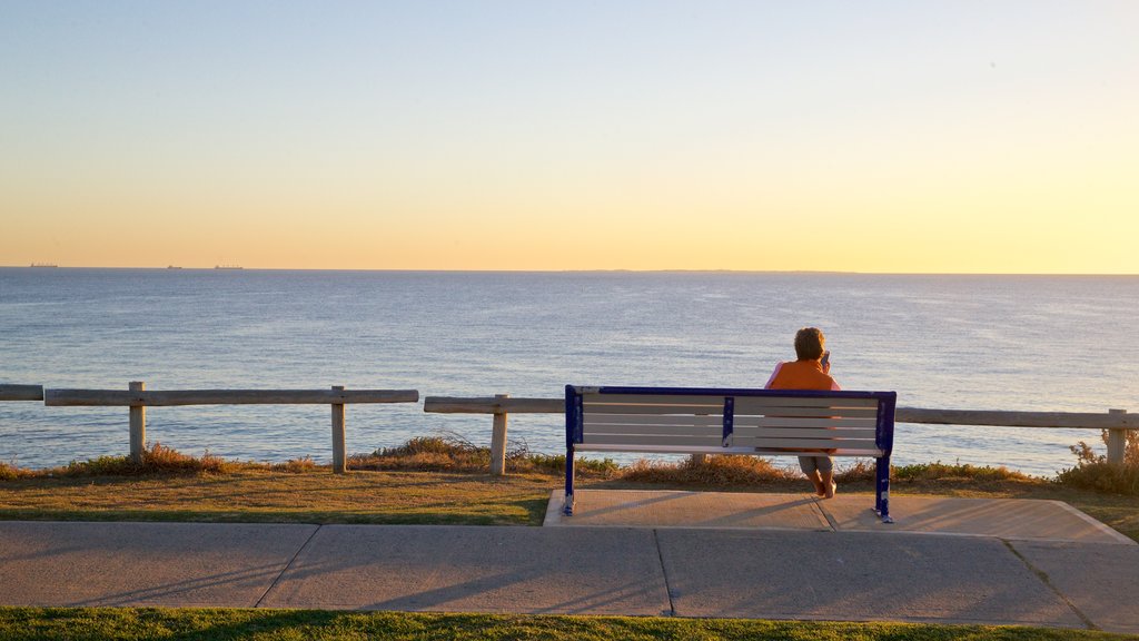 Cottesloe Beach which includes a sunset and general coastal views as well as an individual female