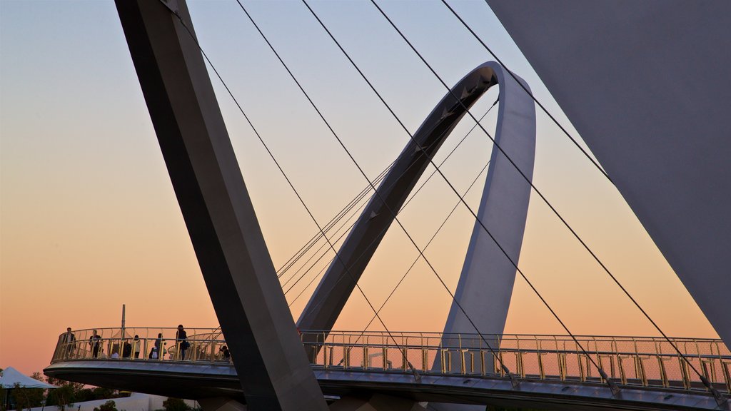 Parque Elizabeth Quay que incluye una puesta de sol y un puente