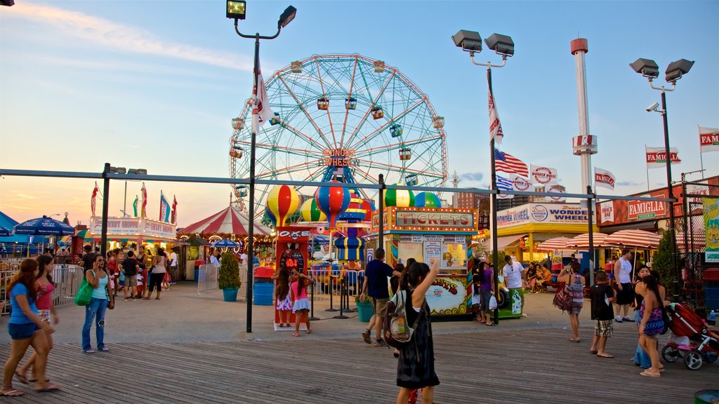 Riegelmann Boardwalk featuring a sunset as well as a small group of people