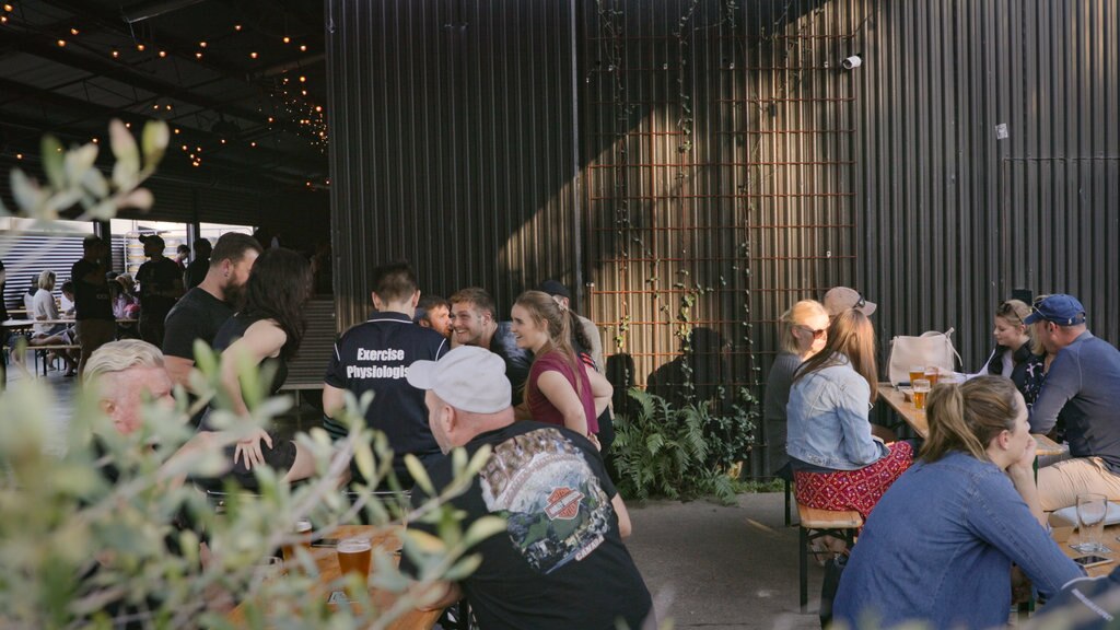 Cervecería All Inn Brewing Co. mostrando comidas al aire libre y también un pequeño grupo de personas