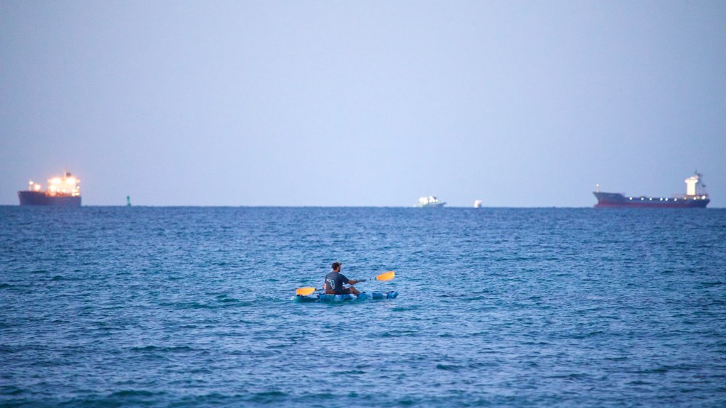 Dania Beach que incluye vistas generales de la costa y kayak o canoa y también un hombre