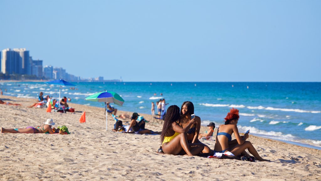 Playa de Fort Lauderdale que incluye una playa de arena y vista general a la costa y también un pequeño grupo de personas