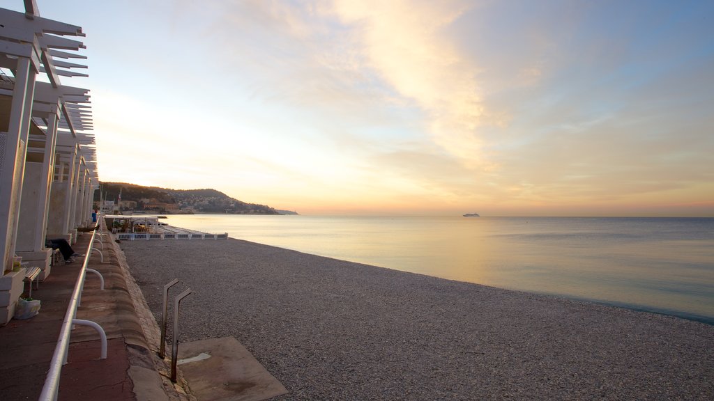 Promenade des Anglais showing a beach, a sunset and a pebble beach