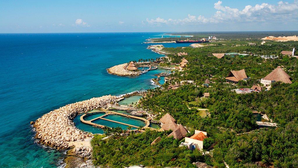 Parque temático ecológico Xcaret que incluye una ciudad costera, vista general a la costa y un hotel de lujo o resort