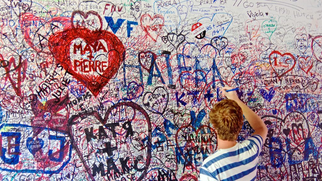 Casa di Giulietta mostrando arte ao ar livre assim como um homem sozinho