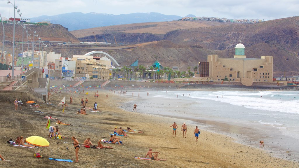 Playa de Las Canteras mostrando uma cidade litorânea, uma praia e paisagens litorâneas