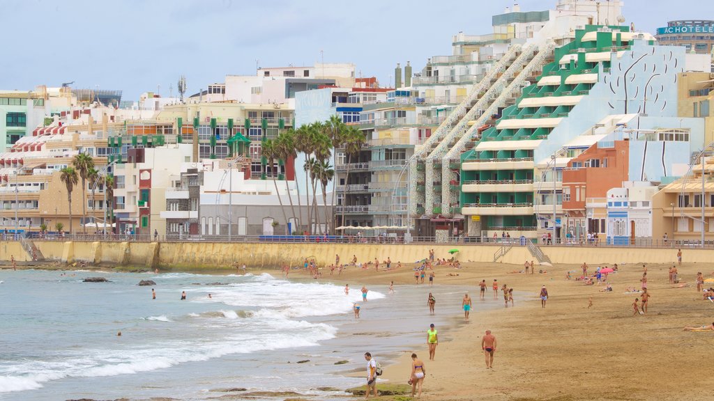 Playa de Las Canteras ofreciendo una ciudad costera, una playa de arena y vistas generales de la costa