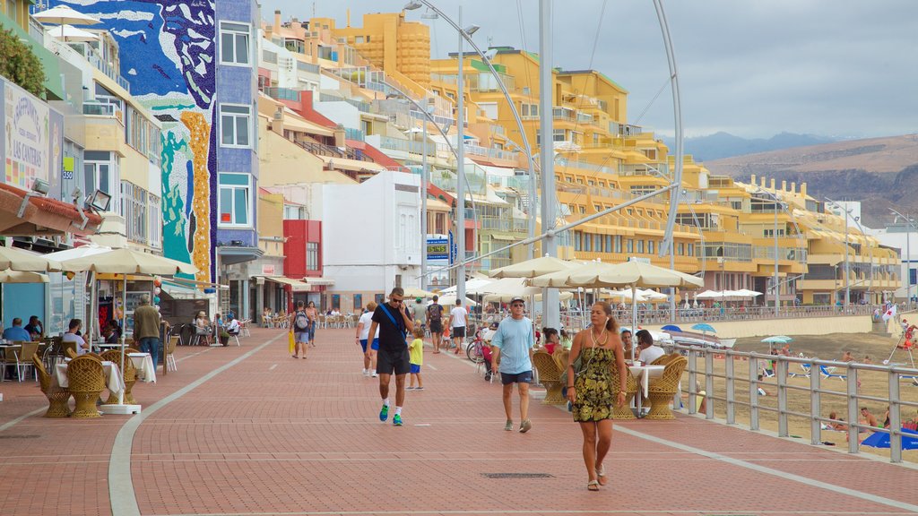 Playa de Las Canteras que incluye vista general a la costa y una ciudad costera y también un pequeño grupo de personas