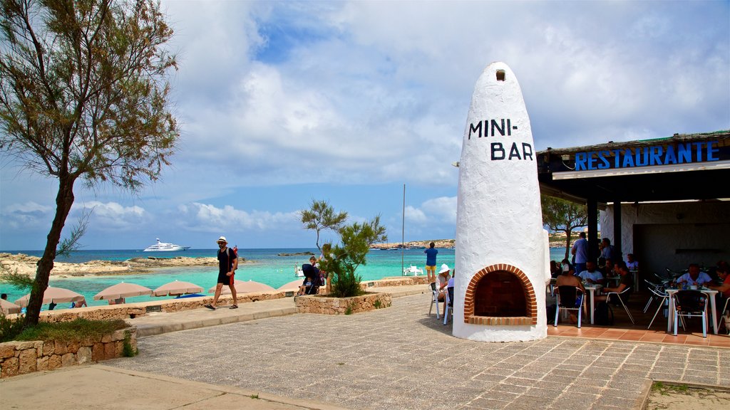 Es Pujols Beach featuring signage and a coastal town