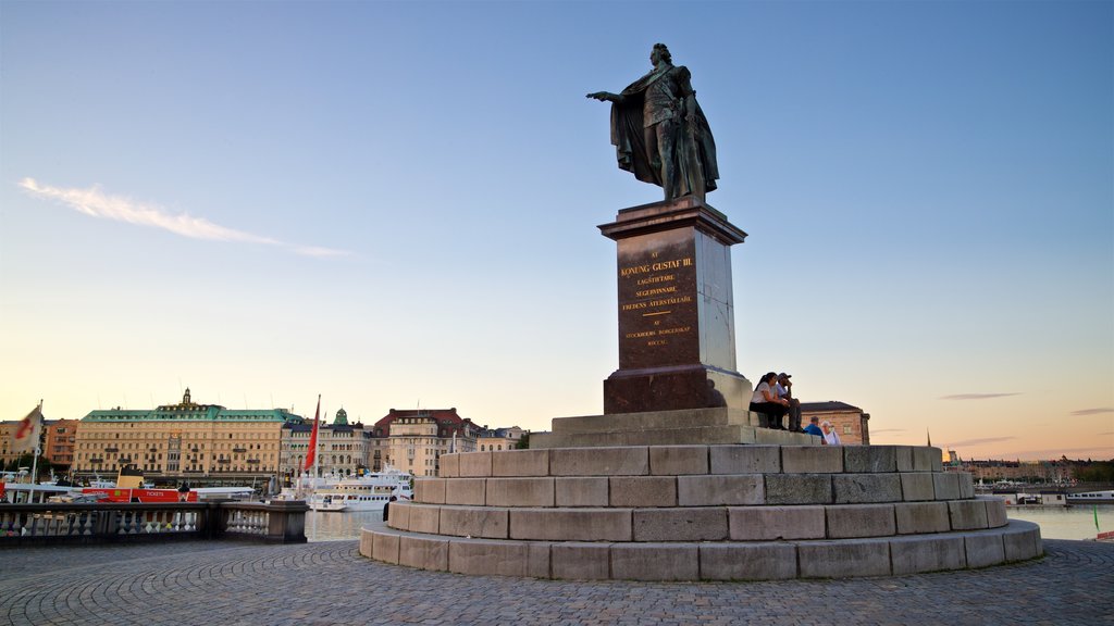 Gamla Stan ofreciendo un atardecer y una estatua o escultura