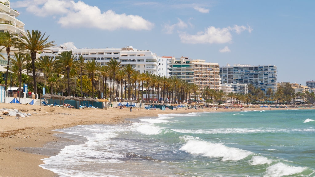 Paseo marítimo de Marbella que incluye una playa de arena, una ciudad costera y vistas generales de la costa