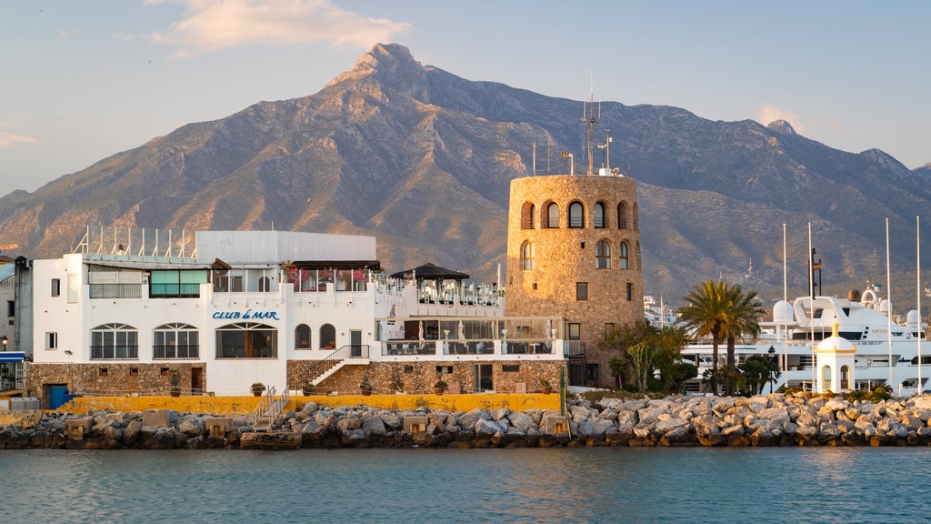 Puerto Banus Marina som omfatter en kystby, en solnedgang og bjerge