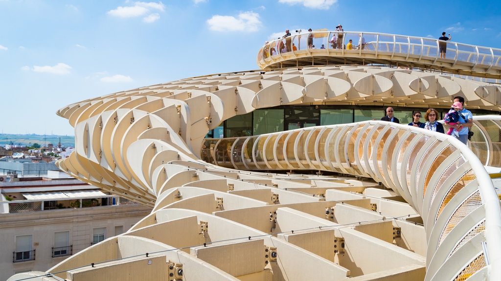 Metropol Parasol que inclui arquitetura moderna e paisagens assim como um pequeno grupo de pessoas