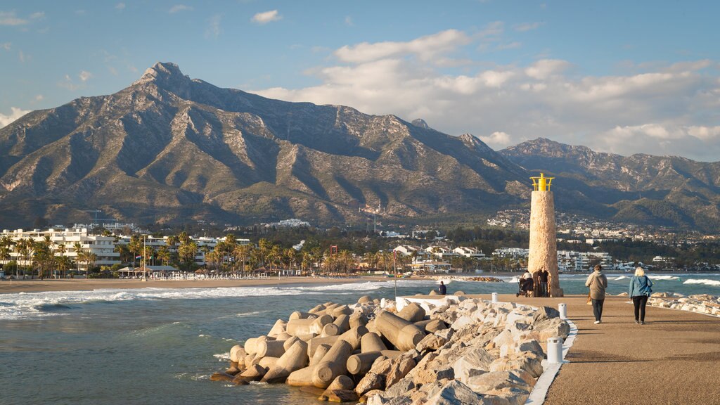 Puerto Banus Beach which includes a lighthouse, mountains and a coastal town