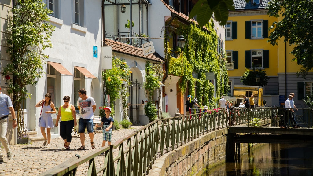 Ciudad Vieja que incluye escenas urbanas y un río o arroyo y también una familia